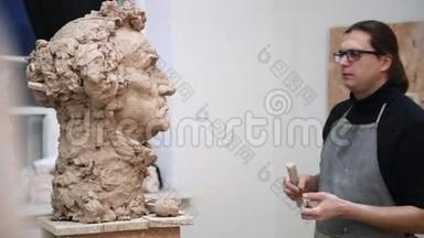 雕塑家造型雕塑调整面细节头由粘土制成。